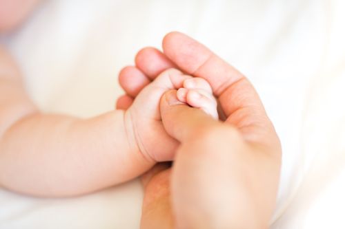 Father holding the hand of his new born son, shallow DOF