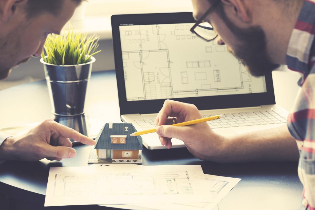 architect showing new family house model to customer at office